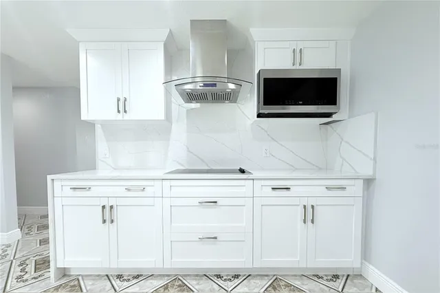 a kitchen with white cabinets and stainless steel appliances
