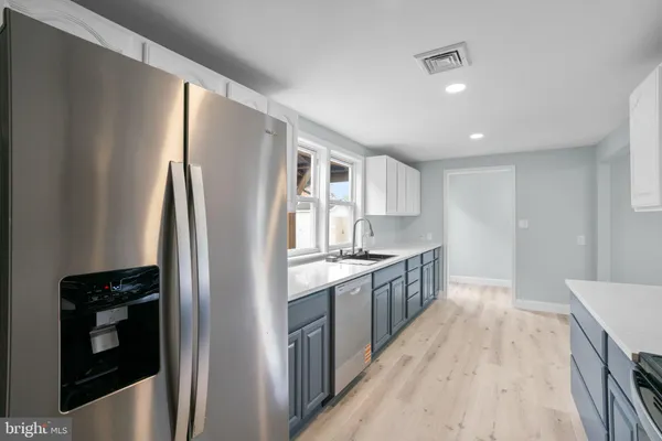 a kitchen with stainless steel appliances granite countertop a refrigerator a stove and a sink