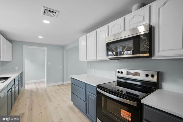 a kitchen with cabinets and steel appliances