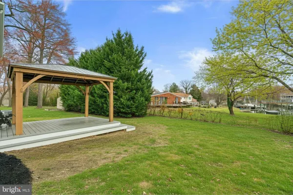 a view of a house with a big yard and large trees