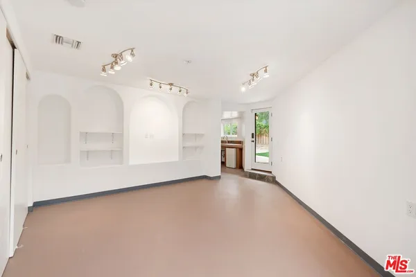 a view of an empty room with a fireplace and windows