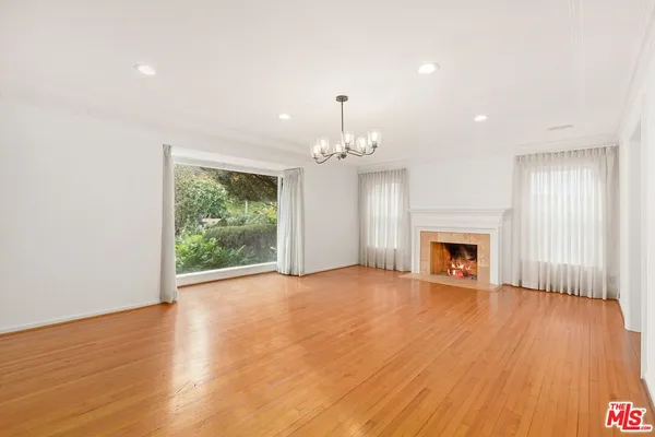 a view of empty room with wooden floor and fireplace