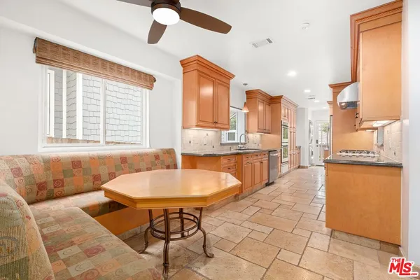 a kitchen with a dining table chairs and a refrigerator