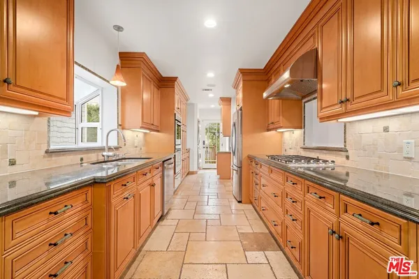 a large kitchen with stainless steel appliances granite countertop a stove and a sink