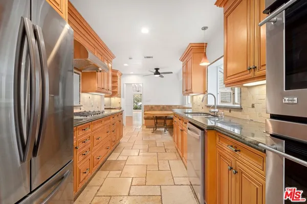 a kitchen with stainless steel appliances granite countertop a refrigerator a sink and dishwasher