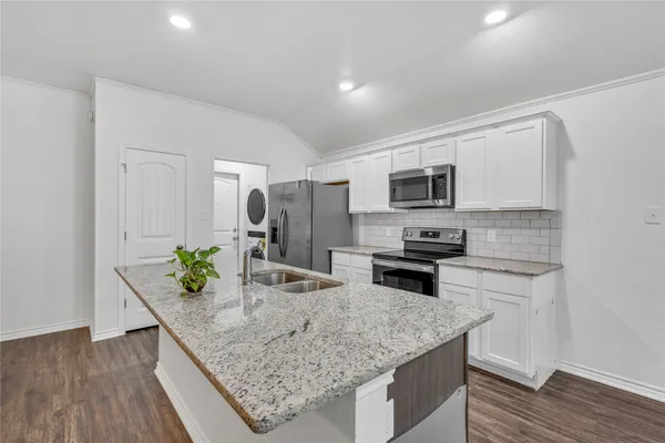 a view of kitchen with refrigerator microwave and stove