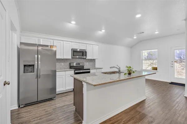 a kitchen with granite countertop stainless steel appliances and wooden cabinets
