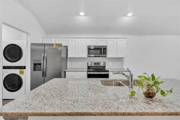 a kitchen with stainless steel appliances a refrigerator sink and stove