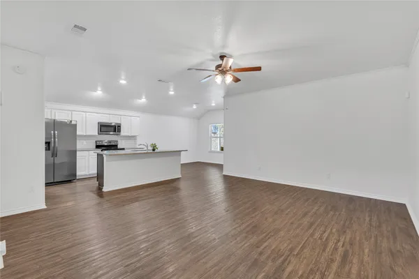 a kitchen with granite countertop kitchen island wooden floors and stainless steel appliances