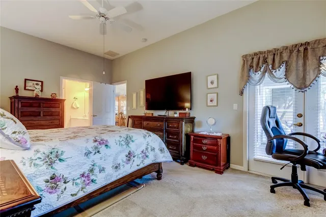 a bedroom with a bed and a flat tv screen on dresser