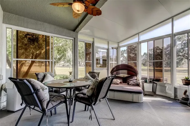 a dining room with furniture and a floor to ceiling window