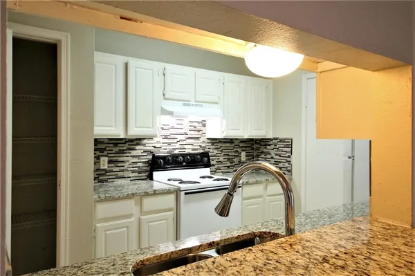 a kitchen with stainless steel appliances kitchen island a white stove top oven and sink