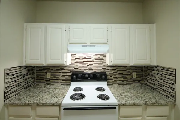 a kitchen with a sink a stove and cabinets