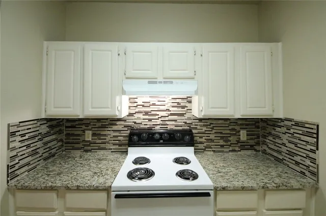 a kitchen with a sink a stove and cabinets