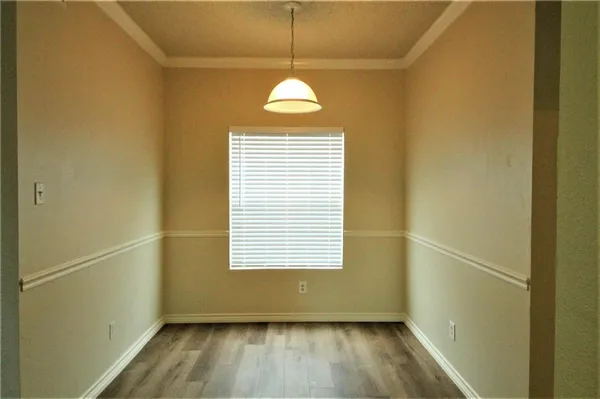a view of a room with wooden floor and a window
