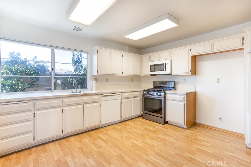 8424 Bayberry Road Rancho Cucamonga, CA 91730 - Photo 11 of 27 a kitchen with granite countertop white cabinets and white appliances