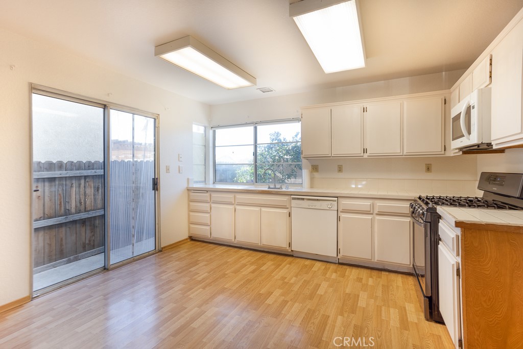 8424 Bayberry Road Rancho Cucamonga, CA 91730 - Photo 9 of 27 a kitchen with stainless steel appliances granite countertop a stove a sink and a refrigerator with wooden floors
