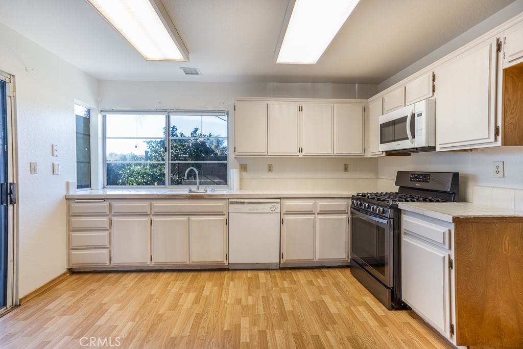8424 Bayberry Road Rancho Cucamonga, CA 91730 - Photo 10 of 27 a kitchen with stainless steel appliances granite countertop a stove a sink and a microwave