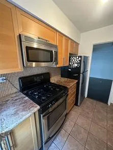 a kitchen with granite countertop a stove and a microwave
