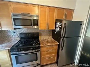 a kitchen with granite countertop a refrigerator stove and microwave