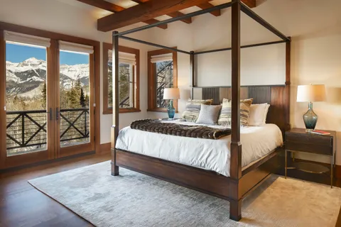 a bedroom with a large bed and wooden floor