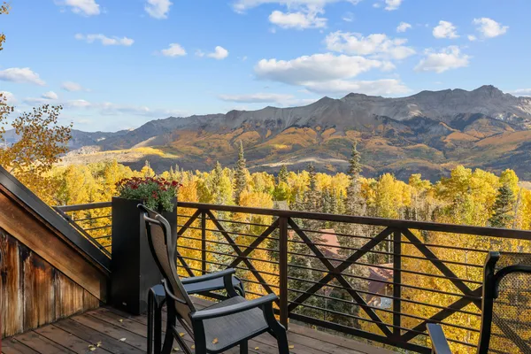 a view of a balcony with furniture and sunset