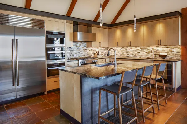 a kitchen with stainless steel appliances granite countertop a sink and a refrigerator