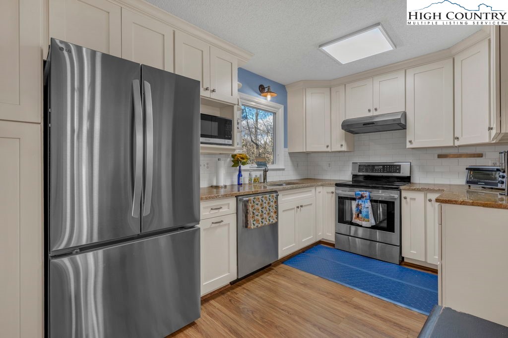 6 Ridgewood Lane Newland, NC 28657 - Photo 9 of 45 a kitchen with a refrigerator cabinets and wooden floor