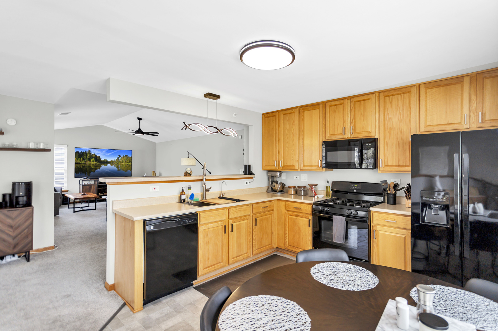 2262 Rockefeller Drive Geneva, IL 60134 - Photo 7 of 25 a kitchen with stainless steel appliances granite countertop a stove top oven a sink a dining table and chairs with wooden floor
