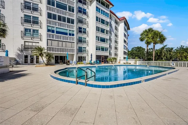 a view of a swimming pool with a bench in front of building