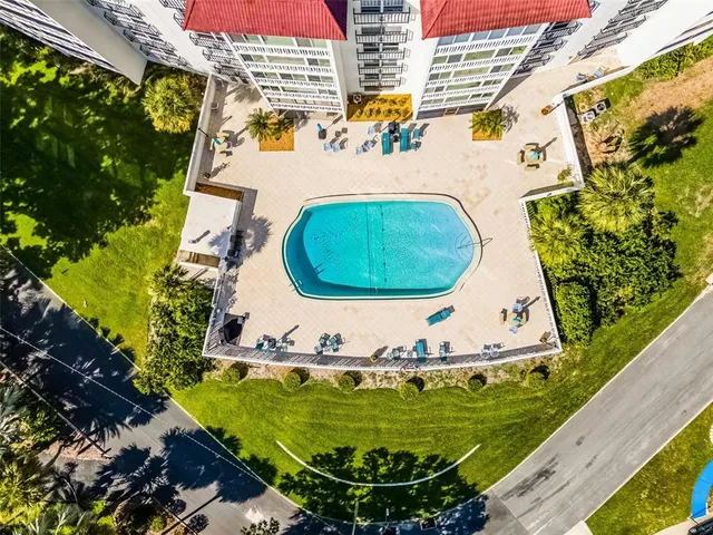 a view of a swimming pool with a yard and sitting space