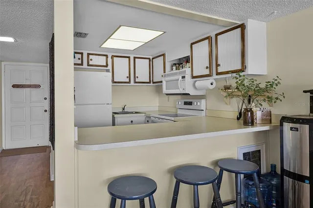 a kitchen with stainless steel appliances granite countertop a sink and a refrigerator