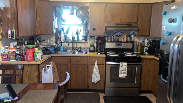 a kitchen with stainless steel appliances a stove a refrigerator and a cabinets