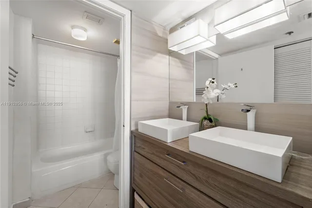 a bathroom with a double vanity sink mirror and shower