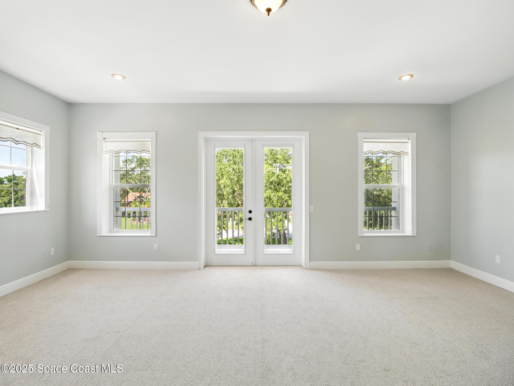 4383 Long Lake Road Melbourne, FL 32934 - Photo 38 of 58 a view of a big room with windows and chandelier fan