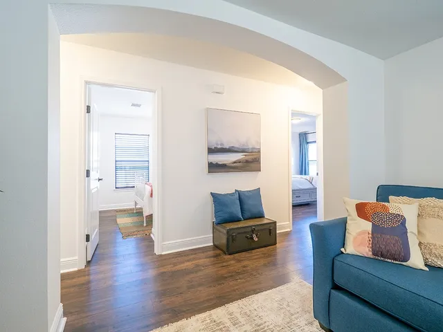 a living room with furniture and a wooden floor