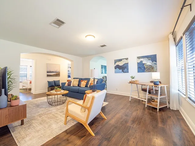a living room with furniture and a wooden floor