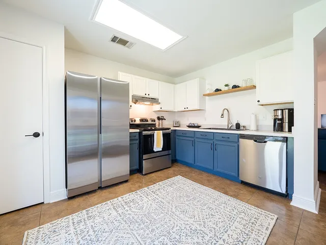 a kitchen with stainless steel appliances granite countertop a refrigerator and a sink