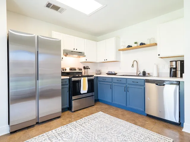 a kitchen with granite countertop stainless steel appliances and a refrigerator