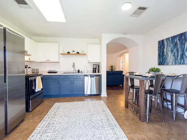 a kitchen with stainless steel appliances kitchen island granite countertop a table and chairs in it