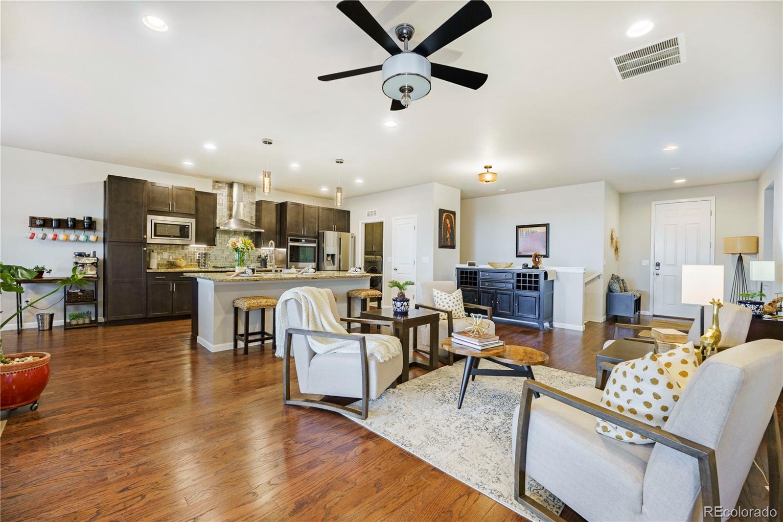 a living room with stainless steel appliances kitchen island granite countertop furniture and a dining table