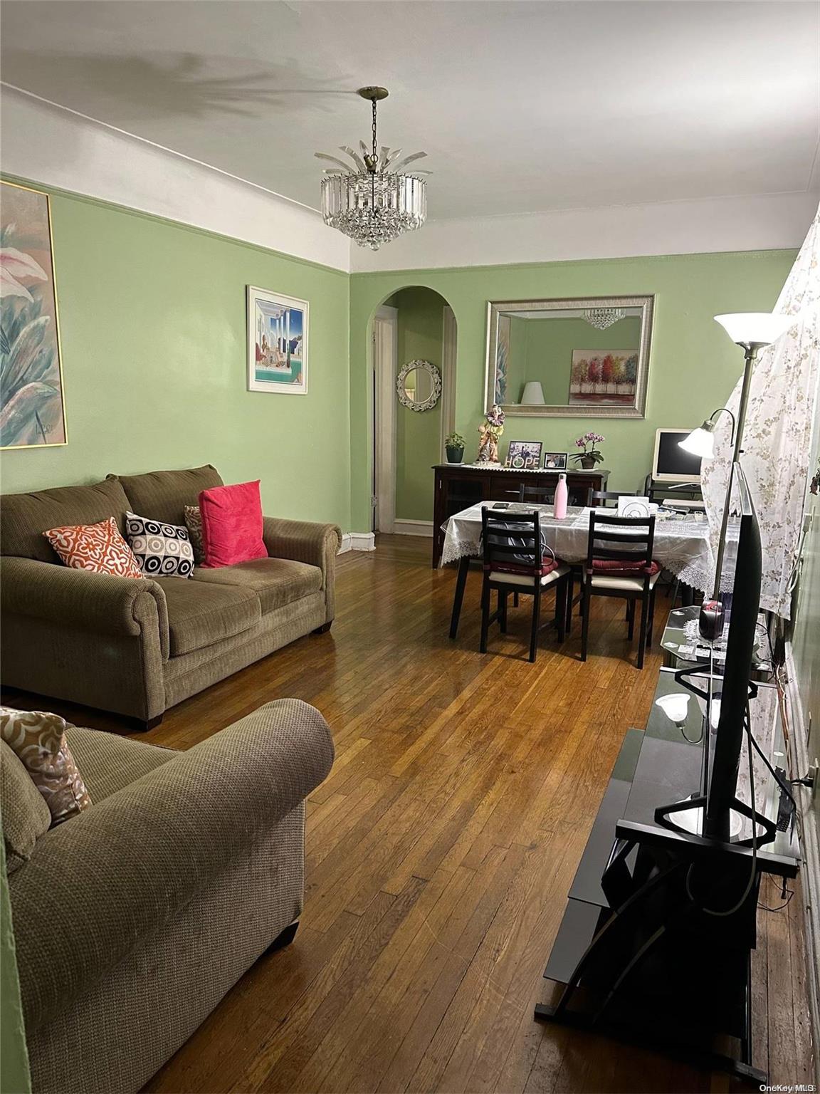 45-20 43rd Street, Unit 1D Queens, NY 11104 - Photo 3 of 8 a living room with furniture and a chandelier