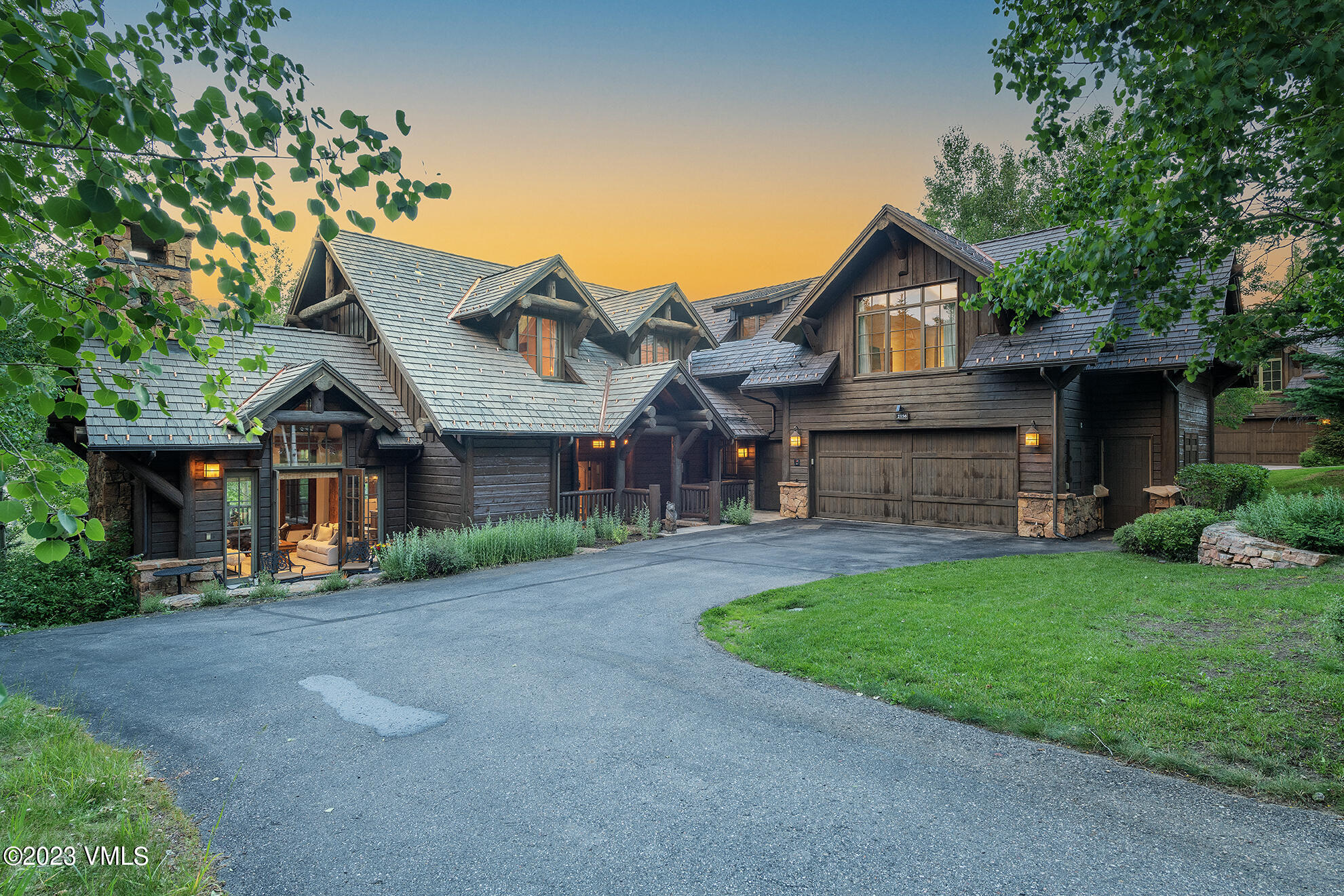 a front view of a house with a garden and trees