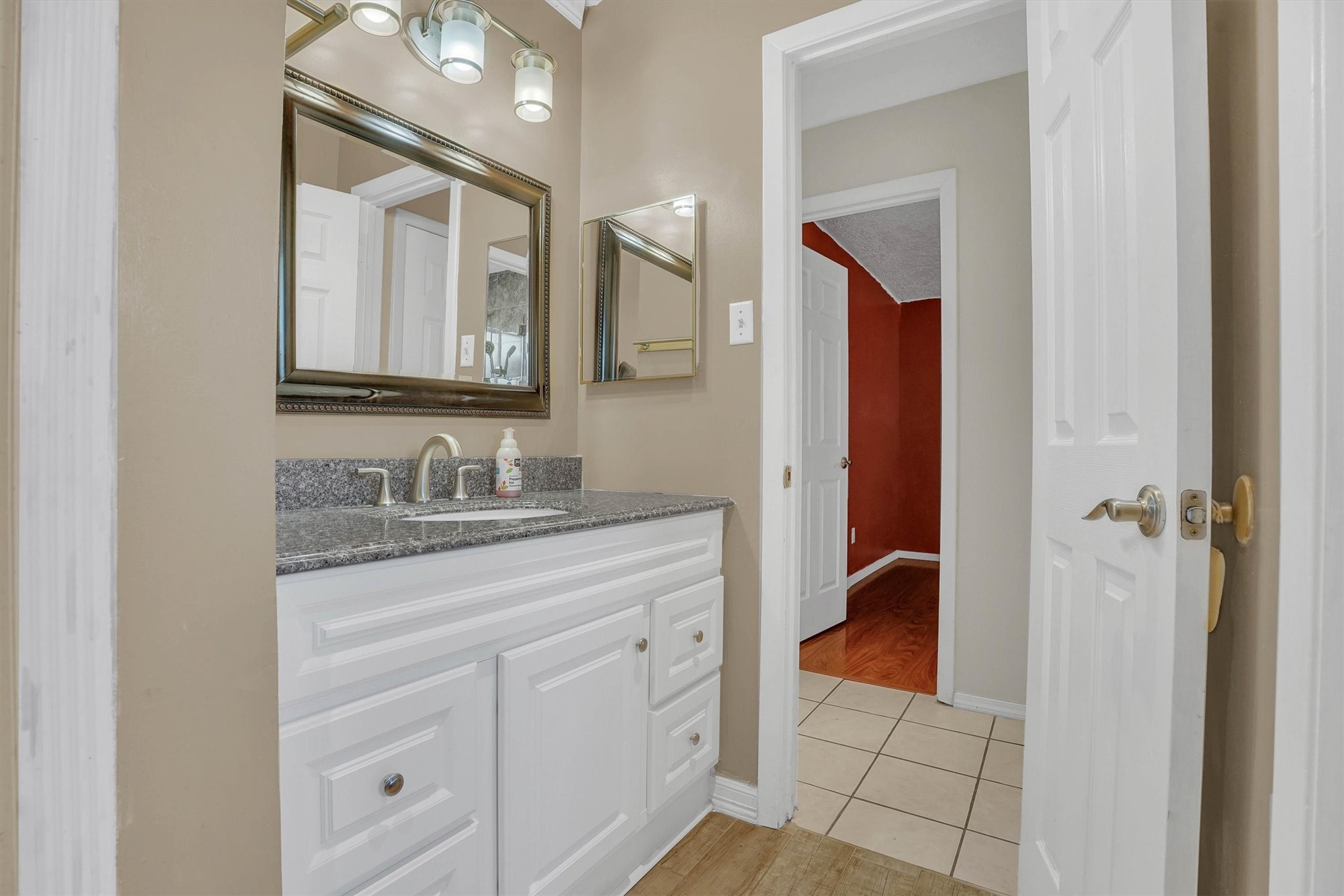 2310 Keyhole Lane Houston, TX 77084 - Photo 20 of 40 a en suite bathroom with a granite countertop sink and a mirror