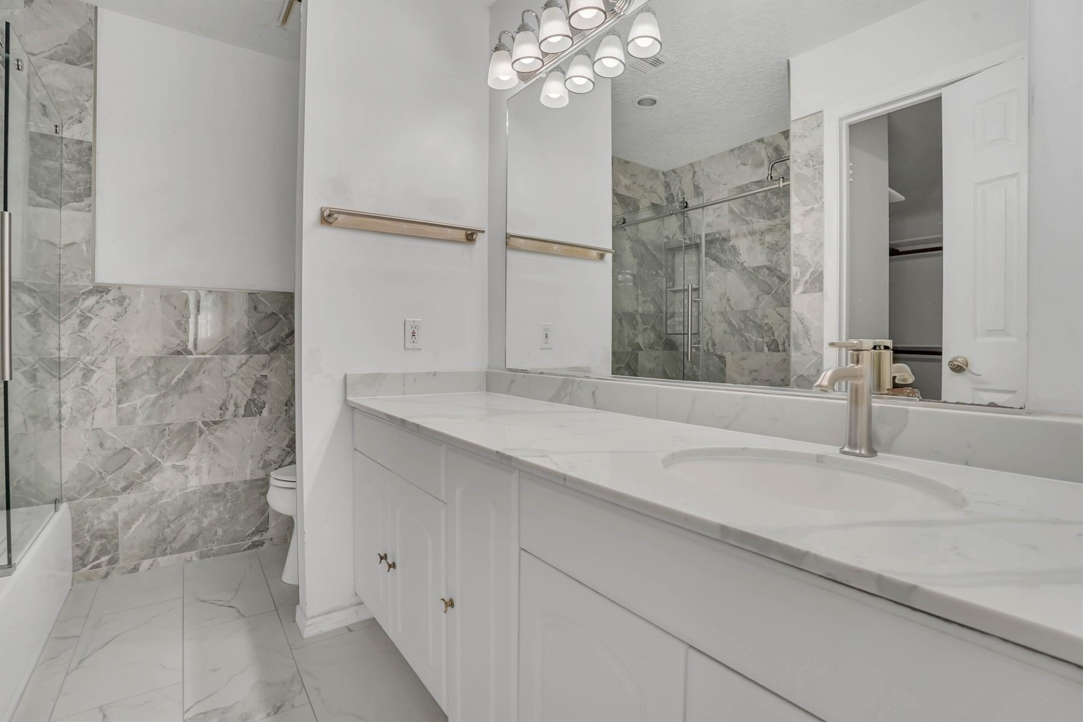 2310 Keyhole Lane Houston, TX 77084 - Photo 33 of 40 a bathroom with a granite countertop sink a large mirror and shower
