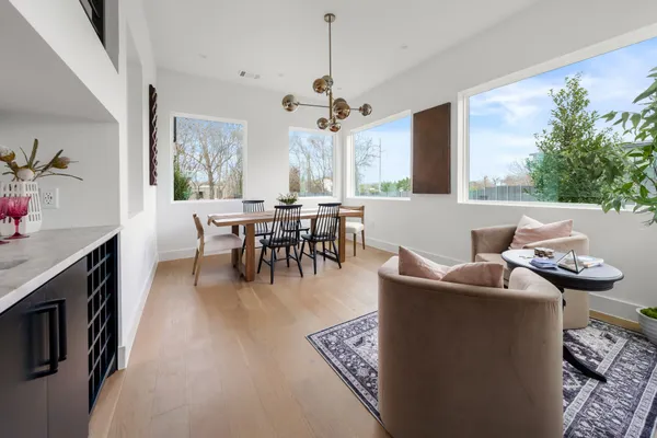 a living room with furniture a chandelier and a dining table