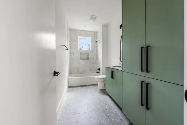 a bathroom with a double vanity sink toilet and shower