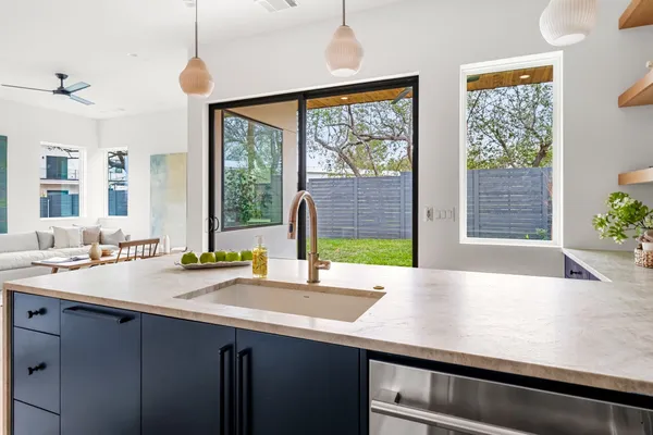 a view of a kitchen with a sink and wooden cabinets