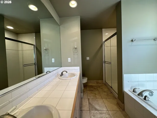 a spacious bathroom with a shower sink and mirror