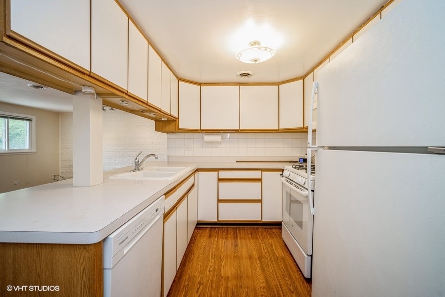 912 Chestnut Street Deerfield, IL 60015 - Photo 11 of 20 a kitchen with a sink a stove cabinets and a wooden floor